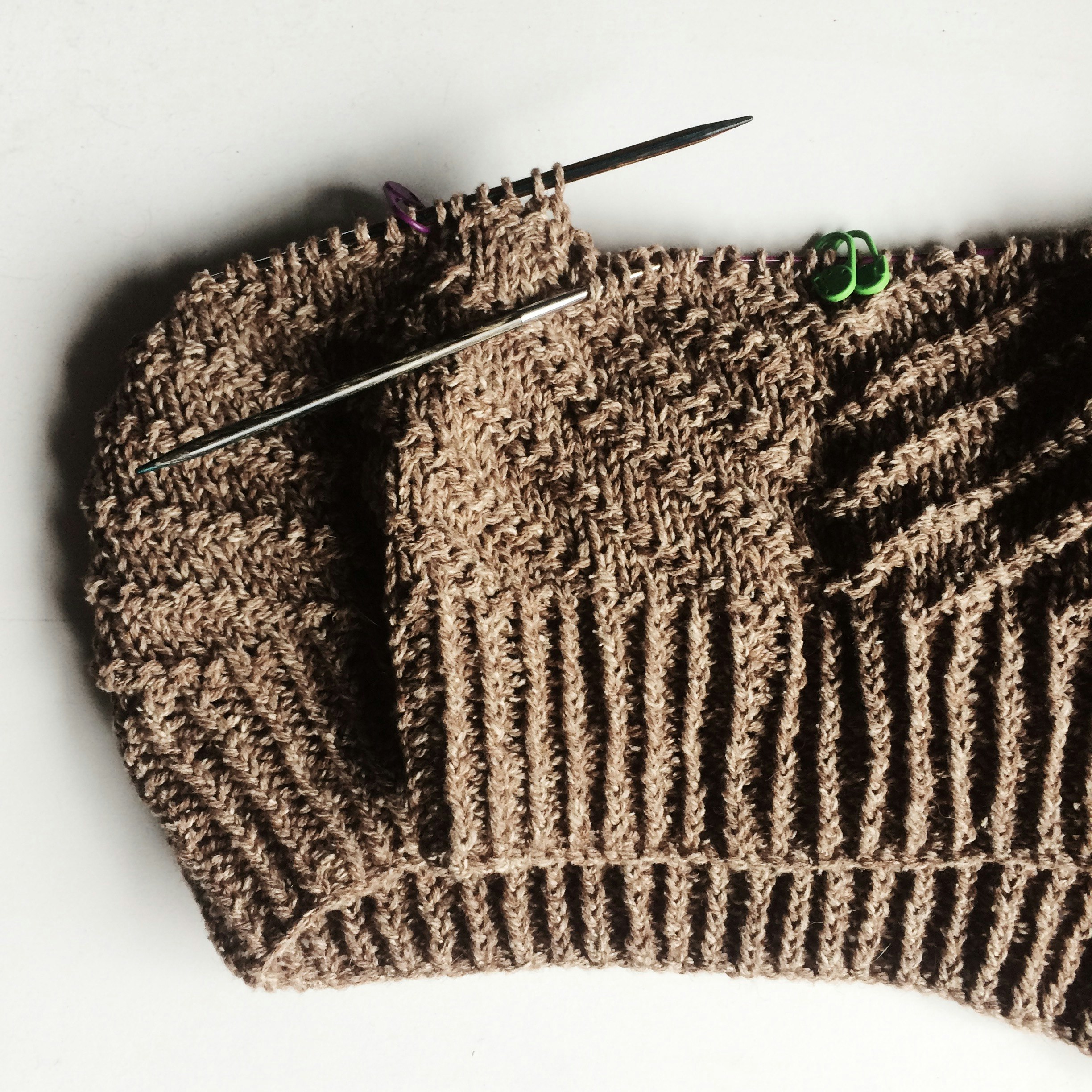 brown knit sweater on white table